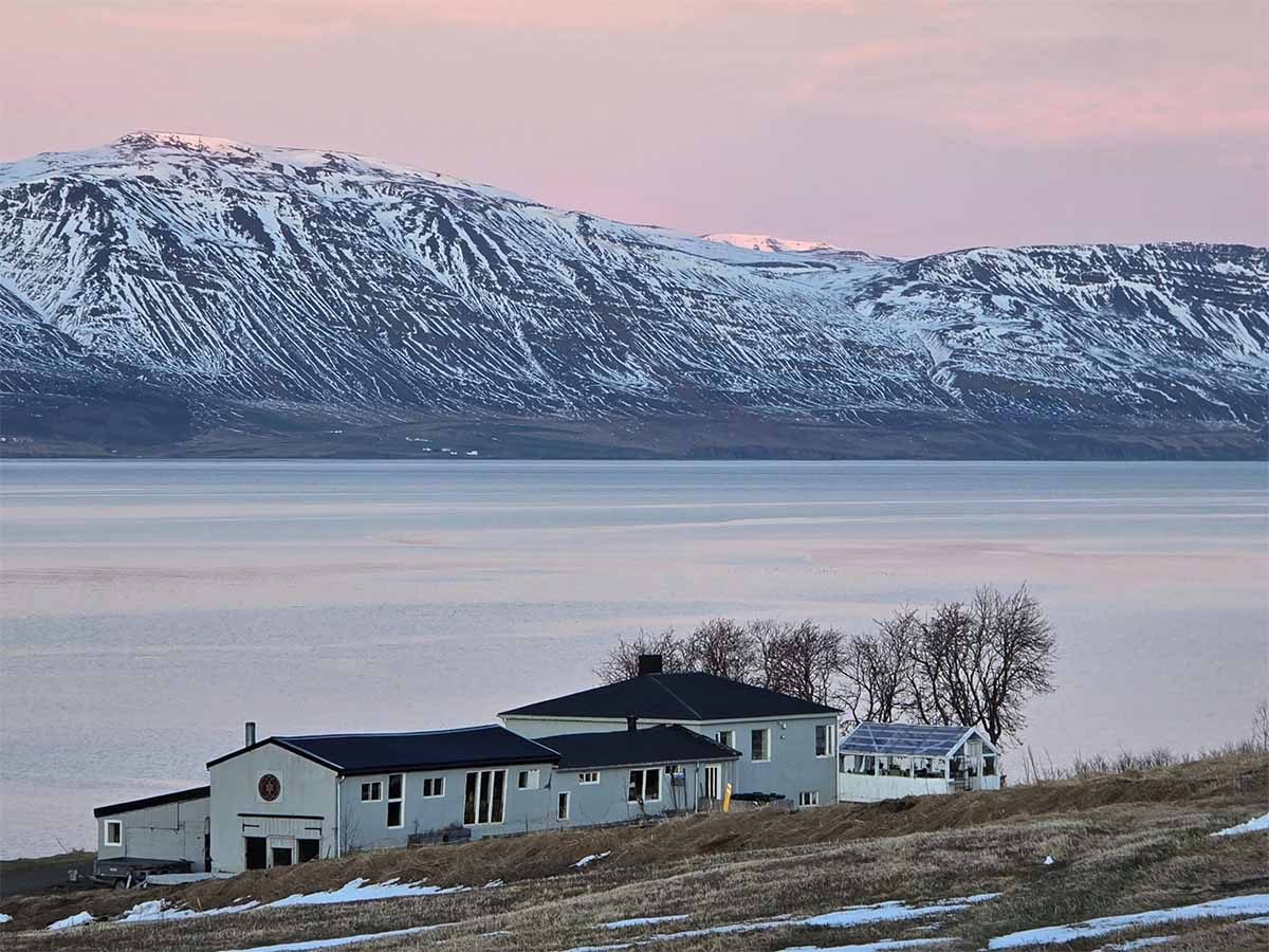 The Iceland yoga retreat house with mountains across a lake
